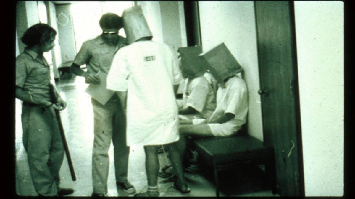 Participantes do experimento da prisão de Stanford no corredor da prisão simulada construída no campus em 1971.