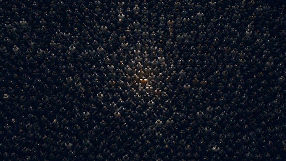 Vista aérea de uma multidão anônima com uma única figura destacada, representando o indivíduo diante do comportamento coletivo.